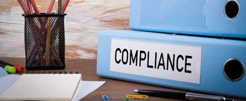 Compliance, Office Binder on Wooden Desk. On the table colored pencils, pen, notebook paper